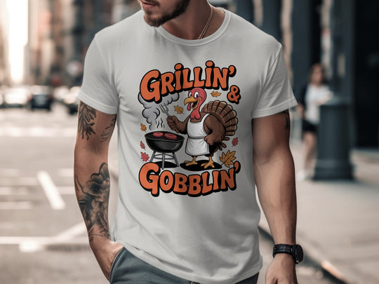 Thanksgiving men’s T-shirt with cartoon turkey grilling and “Grillin’ & Gobblin’” fall design