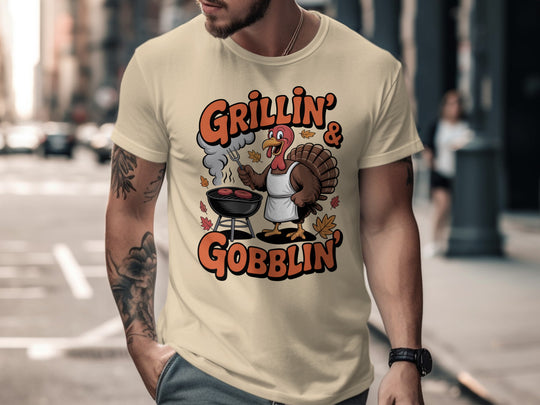 Thanksgiving men’s T-shirt with cartoon turkey grilling and “Grillin’ & Gobblin’” fall design