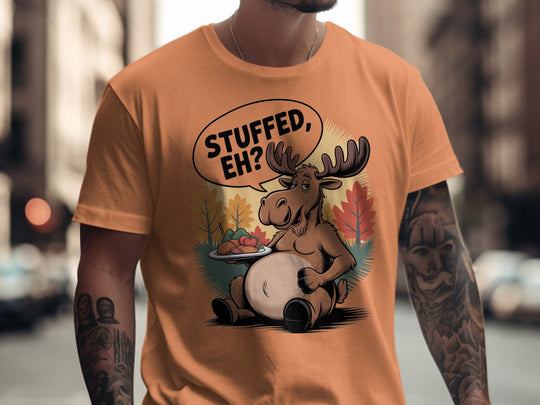 Canadian Thanksgiving men’s T-shirt with cartoon moose saying “Stuffed, Eh?” amid fall trees