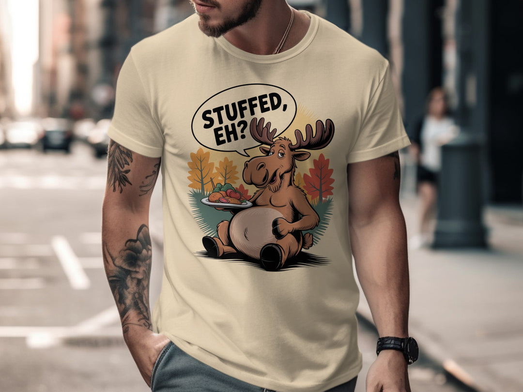 Canadian Thanksgiving men’s T-shirt with cartoon moose saying “Stuffed, Eh?” amid fall trees