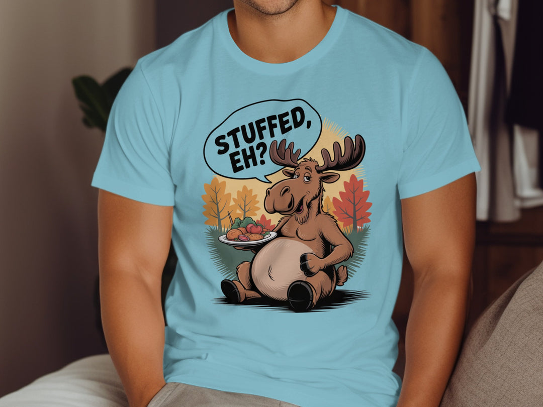 Canadian Thanksgiving men’s T-shirt with cartoon moose saying “Stuffed, Eh?” amid fall trees