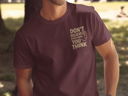 funny men's t-shirt with “don't believe everything you think” quote and spiral head graphic