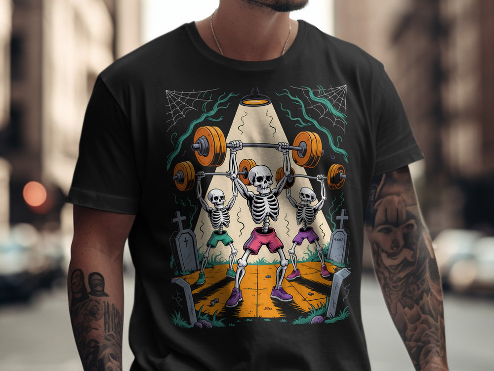 Halloween T-shirt for men with skeletons lifting barbells in a graveyard graphic