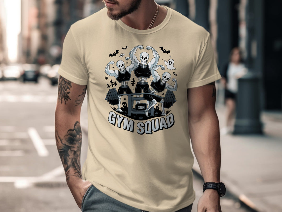 Halloween T-shirt for men with skeletons flexing around a heavy barbell, “Gym Squad” text