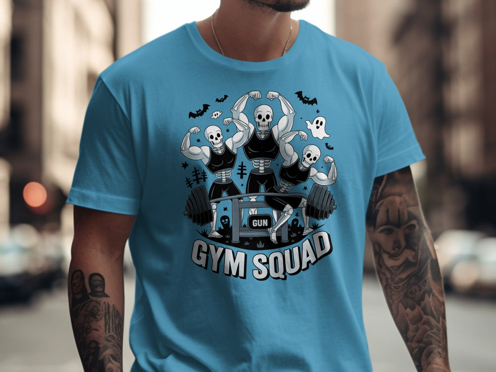 Halloween T-shirt for men with skeletons flexing around a heavy barbell, “Gym Squad” text