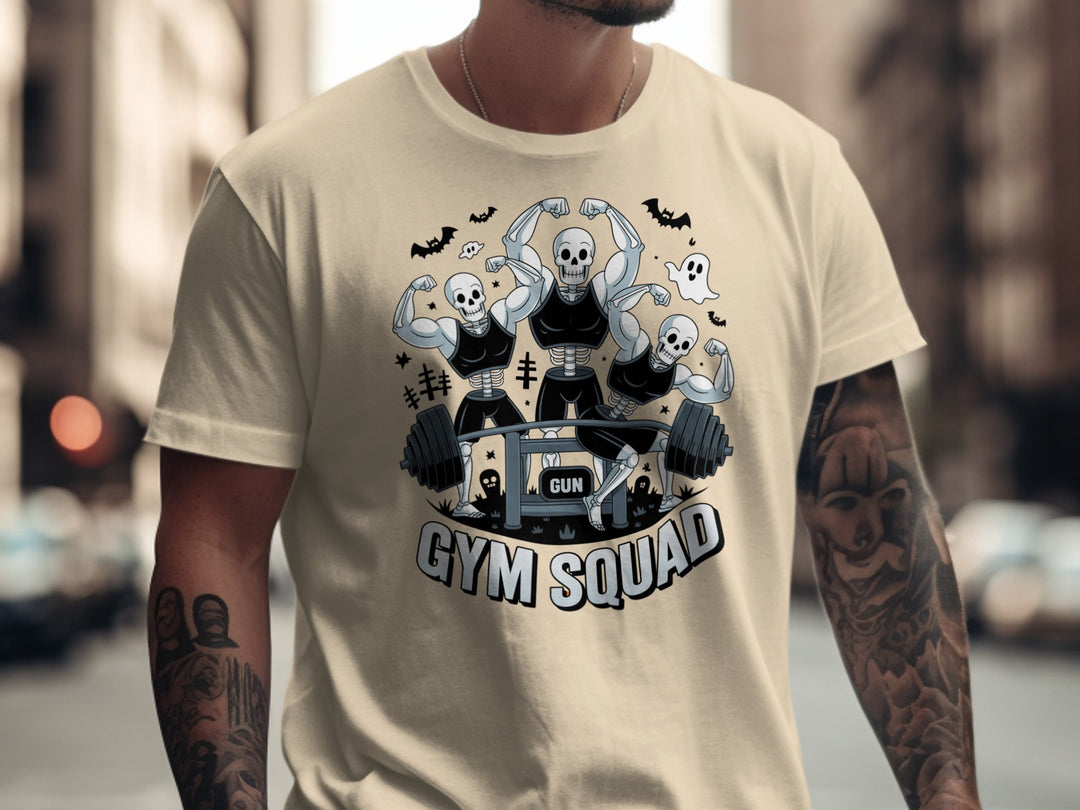 Halloween T-shirt for men with skeletons flexing around a heavy barbell, “Gym Squad” text