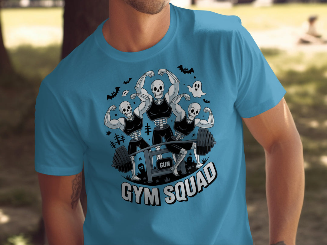 Halloween T-shirt for men with skeletons flexing around a heavy barbell, “Gym Squad” text