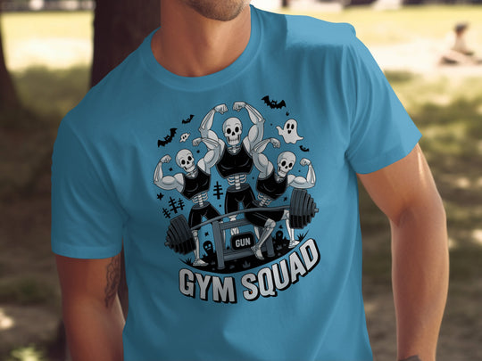 Halloween T-shirt for men with skeletons flexing around a heavy barbell, “Gym Squad” text