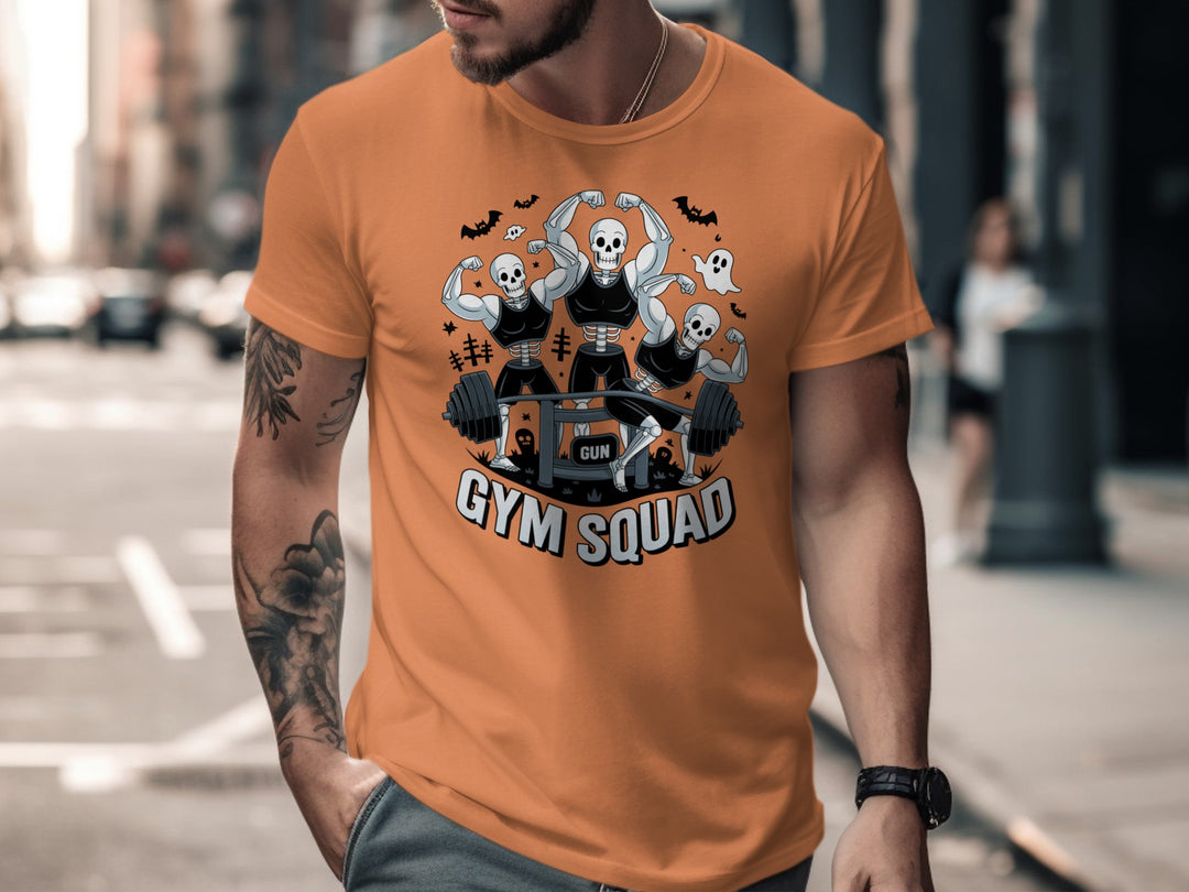 Halloween T-shirt for men with skeletons flexing around a heavy barbell, “Gym Squad” text