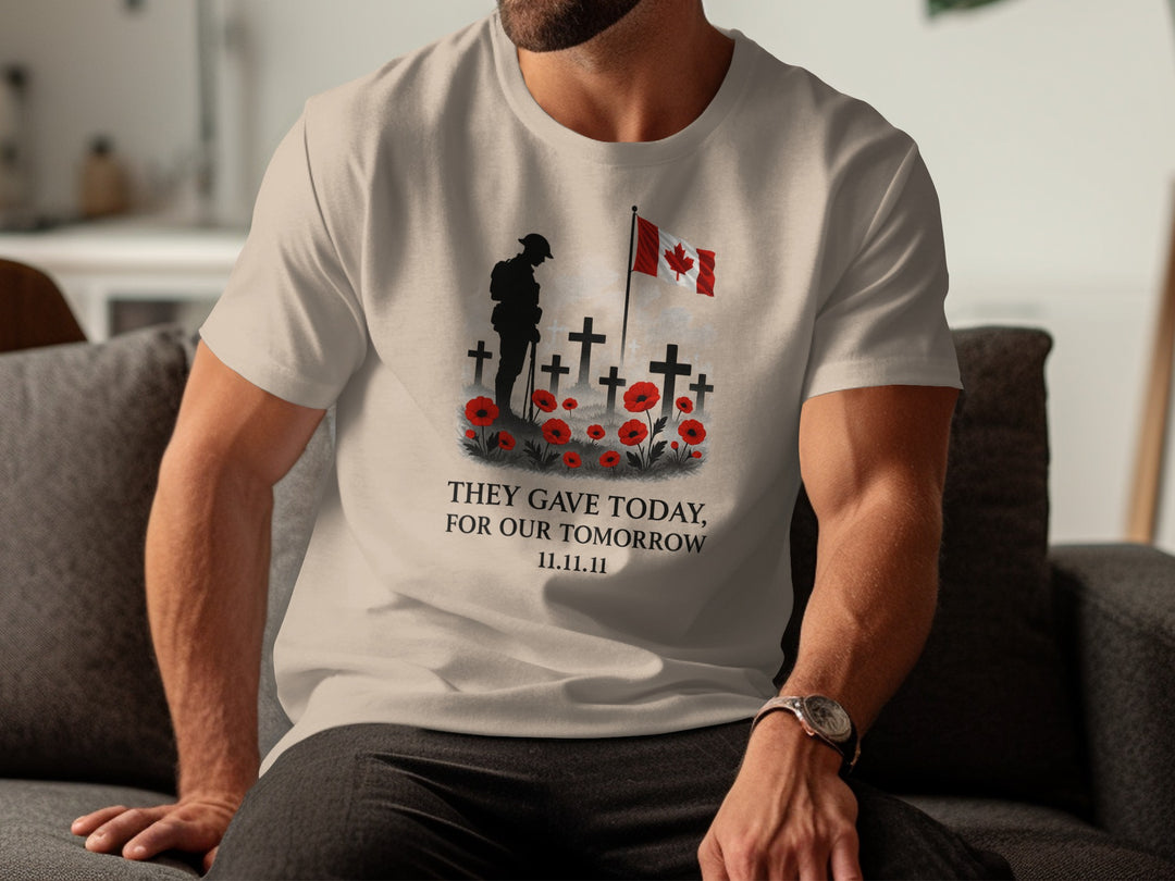 Person wearing a beige t-shirt with a graphic design and text, sitting on a couch.