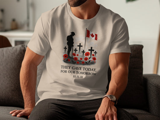 Person wearing a beige t-shirt with a graphic design and text, sitting on a couch.