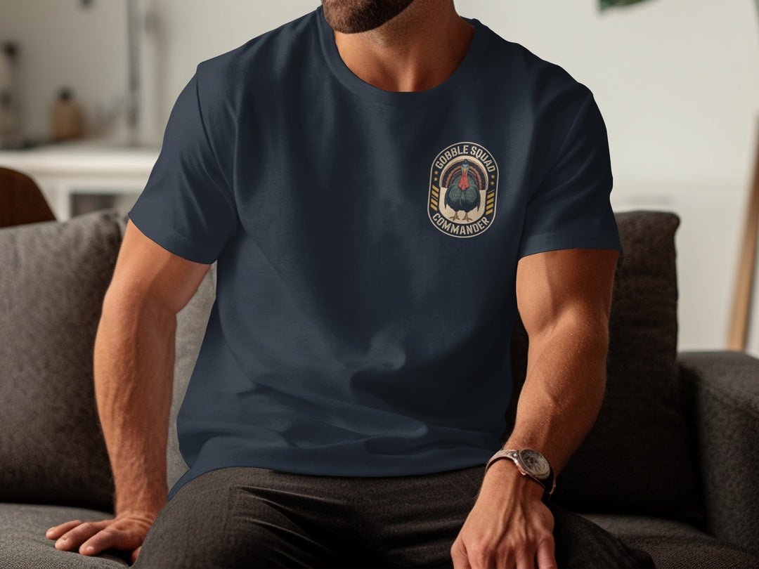 Person wearing a navy blue t-shirt with a logo sitting on a couch.