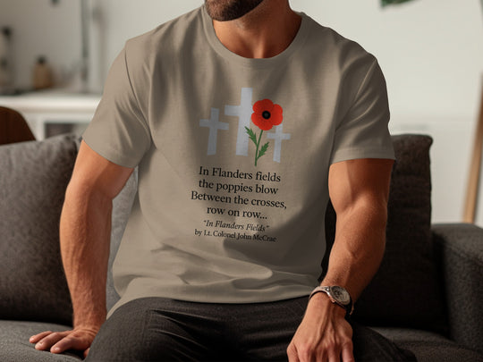 Person wearing a brown savana t-shirt with a poppy design and text, sitting on a couch.