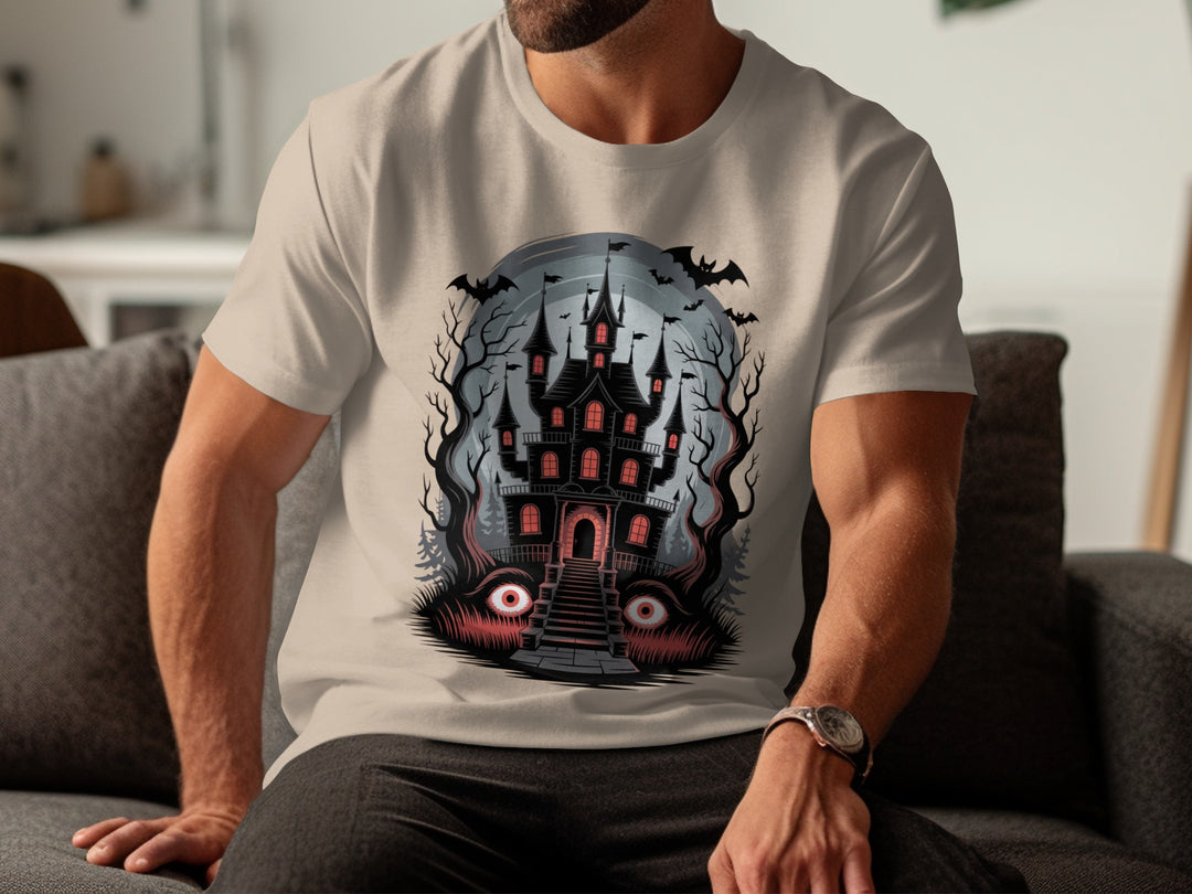 Person wearing a sand color t-shirt with a haunted castle design.
