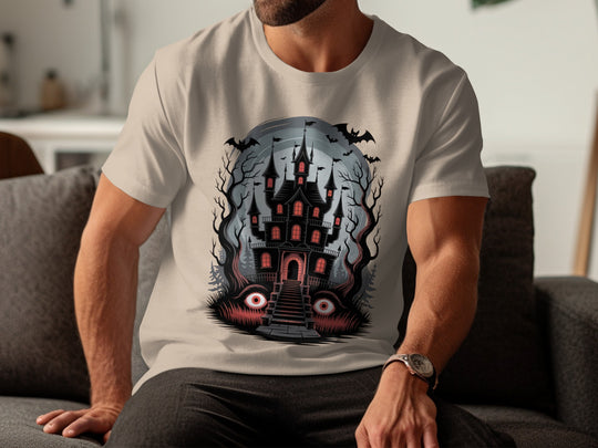 Person wearing a sand color t-shirt with a haunted castle design.
