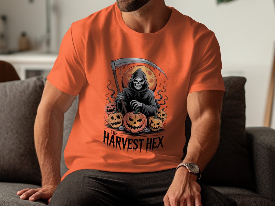 Person wearing an orange t-shirt with a Halloween-themed design featuring a grim reaper and pumpkins.