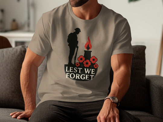 Person wearing a brown savana t-shirt with a 'Lest We Forget' design featuring a silhouette of a soldier, a flame, and flowers.