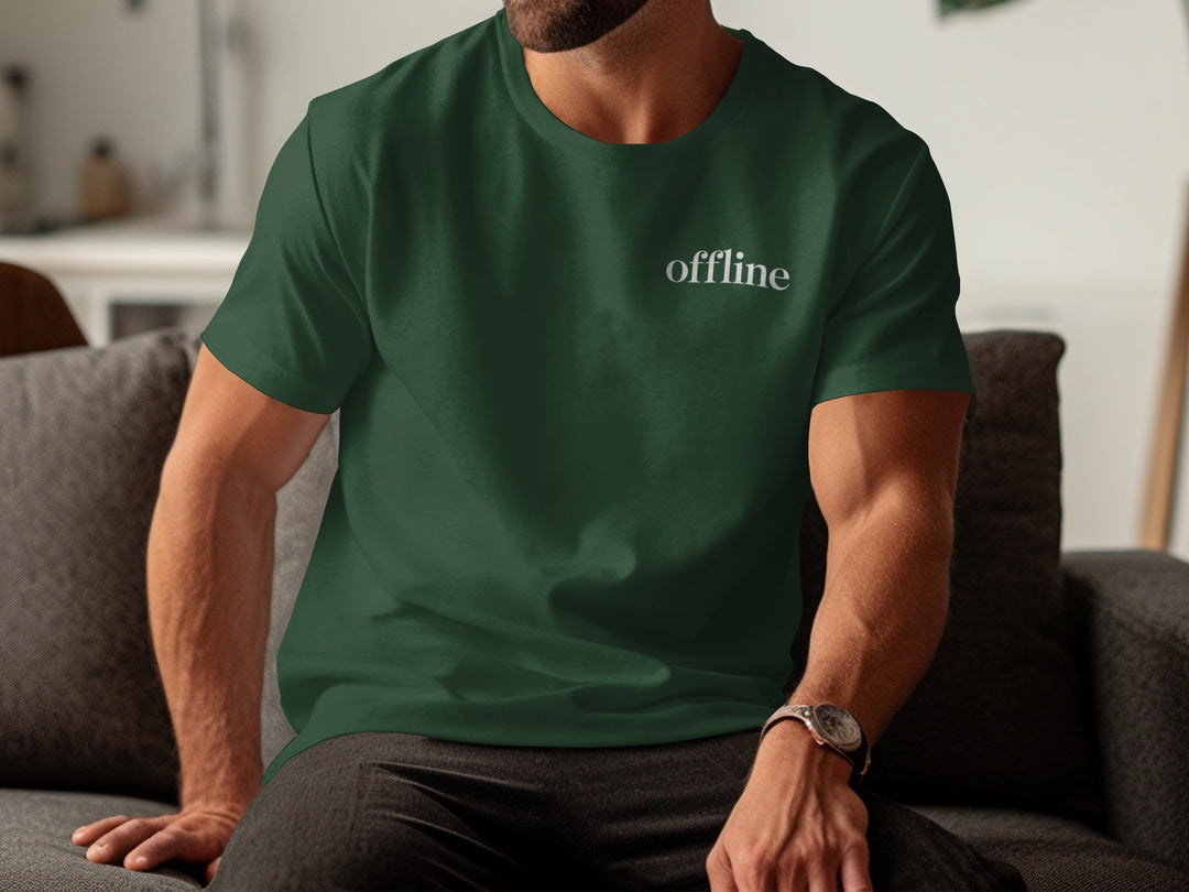 Person wearing a green t-shirt with 'offline' text, sitting on a couch.