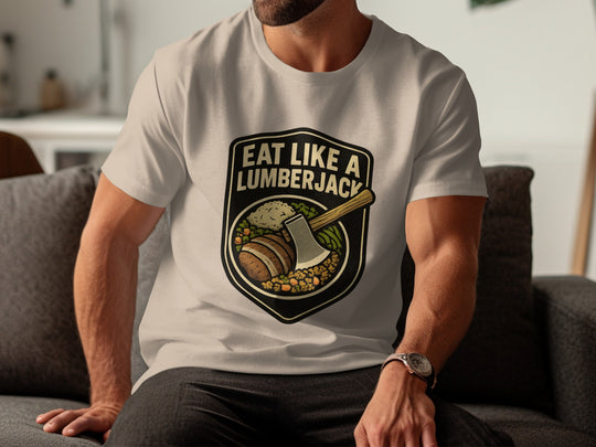 Person wearing a sand color t-shirt with 'Eat Like a Lumberjack' graphic design.