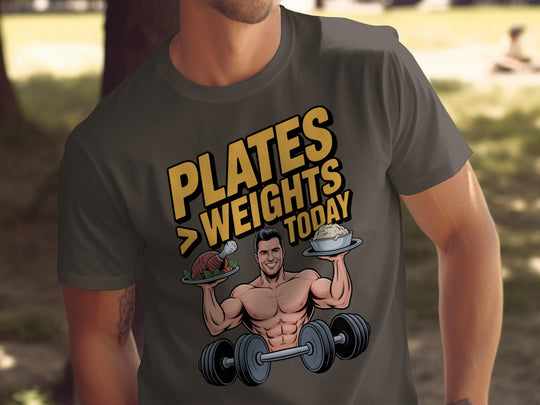 Person wearing a dark chocolate t-shirt with a graphic design of a man lifting weights and text 'PLATES WEIGHTS TODAY'.