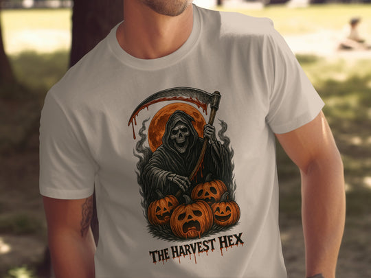 Person wearing a sand color t-shirt with a graphic design of a Grim Reaper and pumpkins, labeled 'The Harvest Hex'.