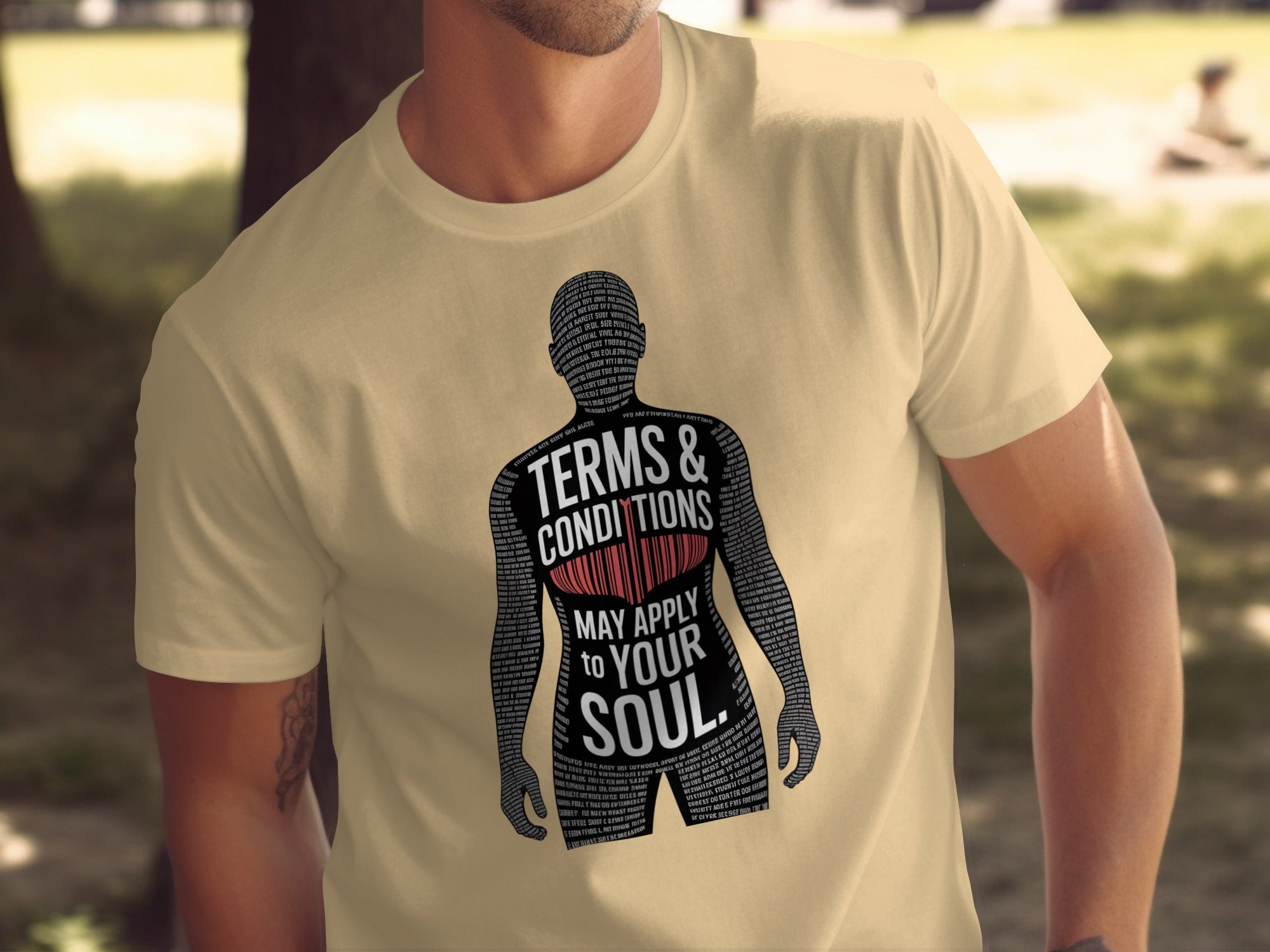 Beige t-shirt with a graphic design and text on a blurred outdoor background