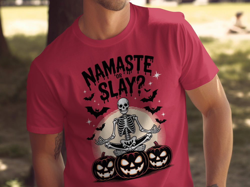 Red t-shirt with a skeleton and pumpkins design and text 'Namaste or Slay?' outdoors.