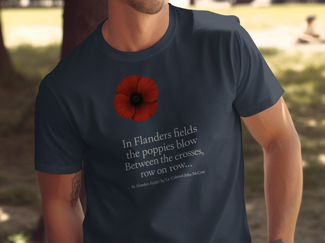 Person wearing a navy blue t-shirt with a red poppy and text in a park setting