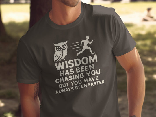 Person wearing a dark chocolate t-shirt with a motivational quote and owl graphic.