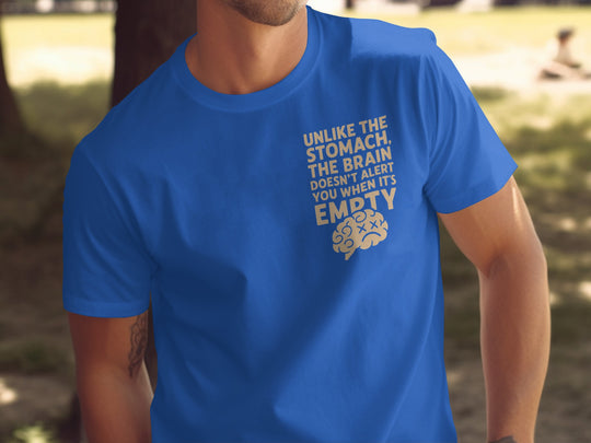Person wearing a royal blue t-shirt with a humorous message and graphic, standing outdoors.