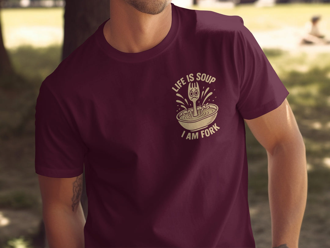 Person wearing a maroon t-shirt with a graphic design and text.
