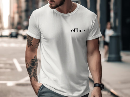 Man wearing a white t-shirt with 'offline' text on a city street.