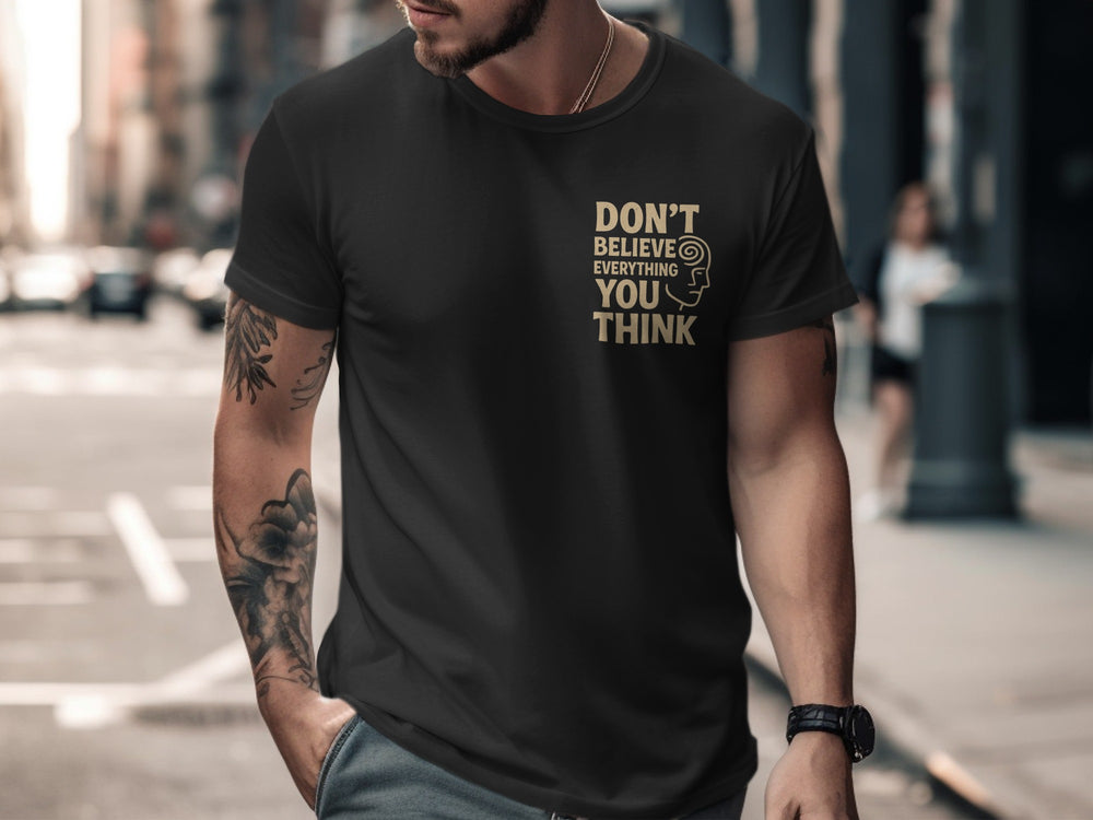 Man wearing a black t-shirt with a motivational quote on a city street.