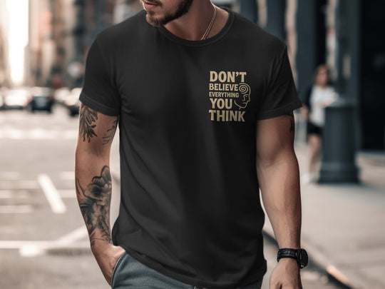 Man wearing a black t-shirt with a motivational quote on a city street.