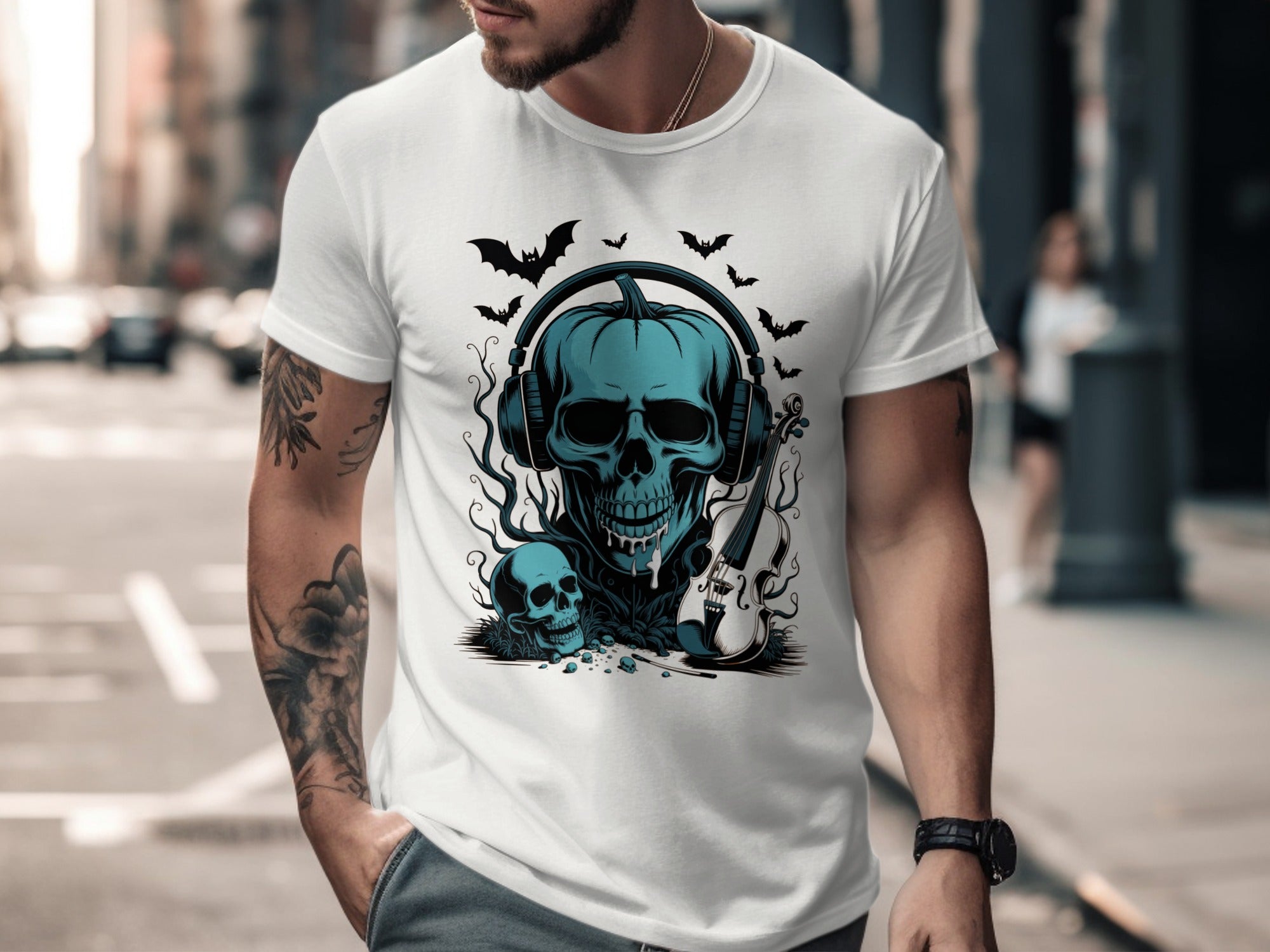 Person wearing a white t-shirt with a blue skull design on a city street.