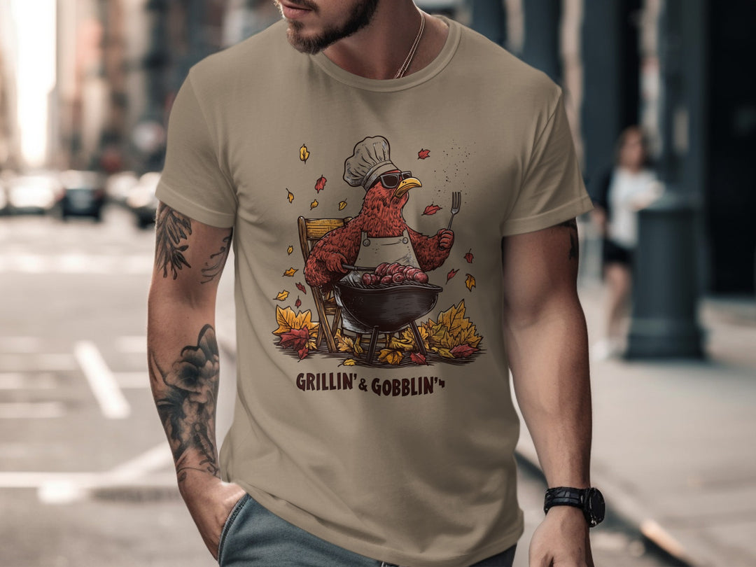 Man wearing a brown t-shirt with a graphic design of a roasted bird and text 'Grillin' & Gobblin'' on a city street.