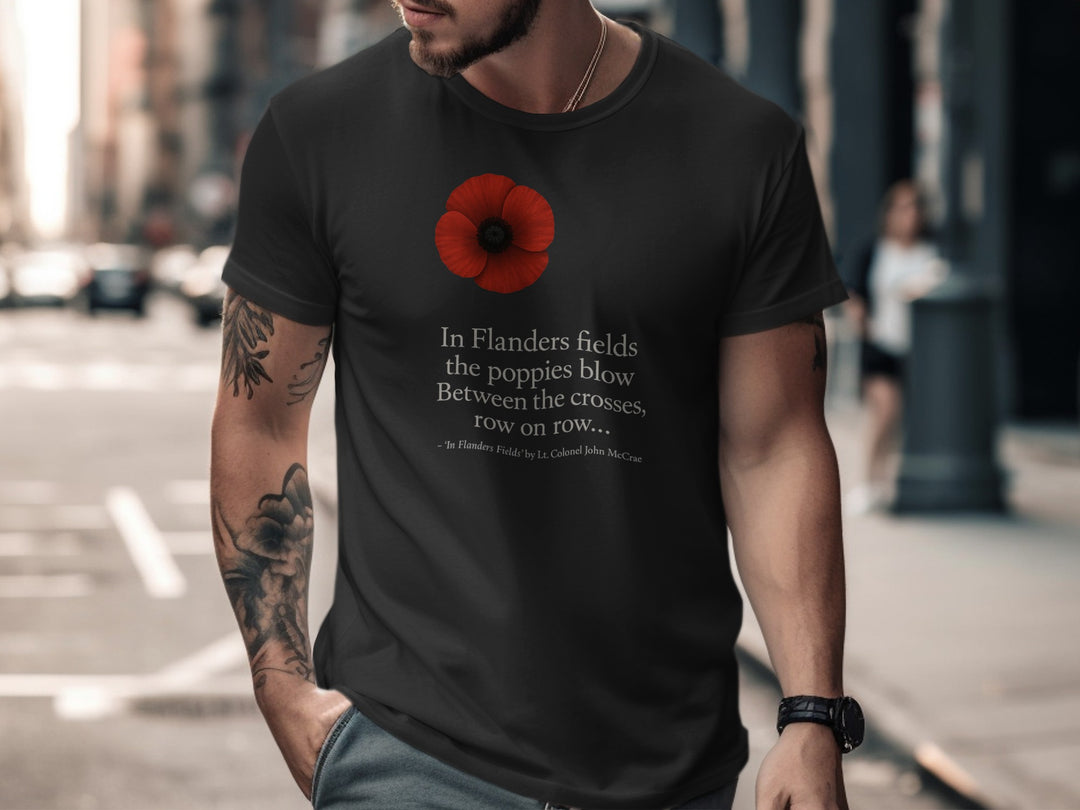 Man wearing a black t-shirt with a red poppy design and text on a city street.