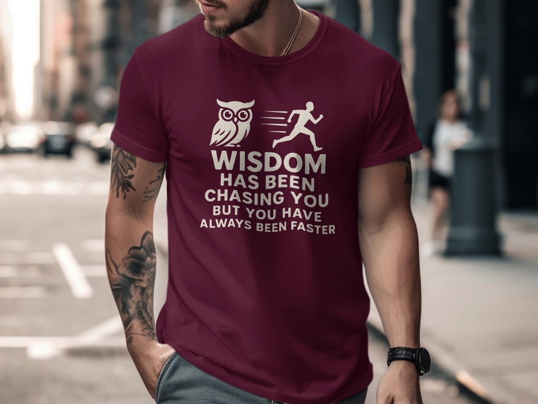 Man wearing a maroon t-shirt with an owl and running person graphic and text on a city street.