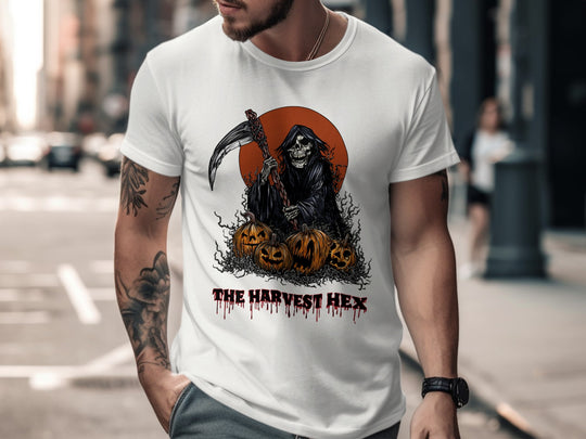 Person wearing a white t-shirt with a graphic design of a skeleton and pumpkins, labeled 'The Harvest Hex', on a city street.