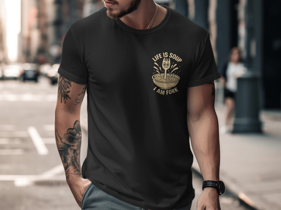 Man wearing a black t-shirt with a graphic design on a city street.