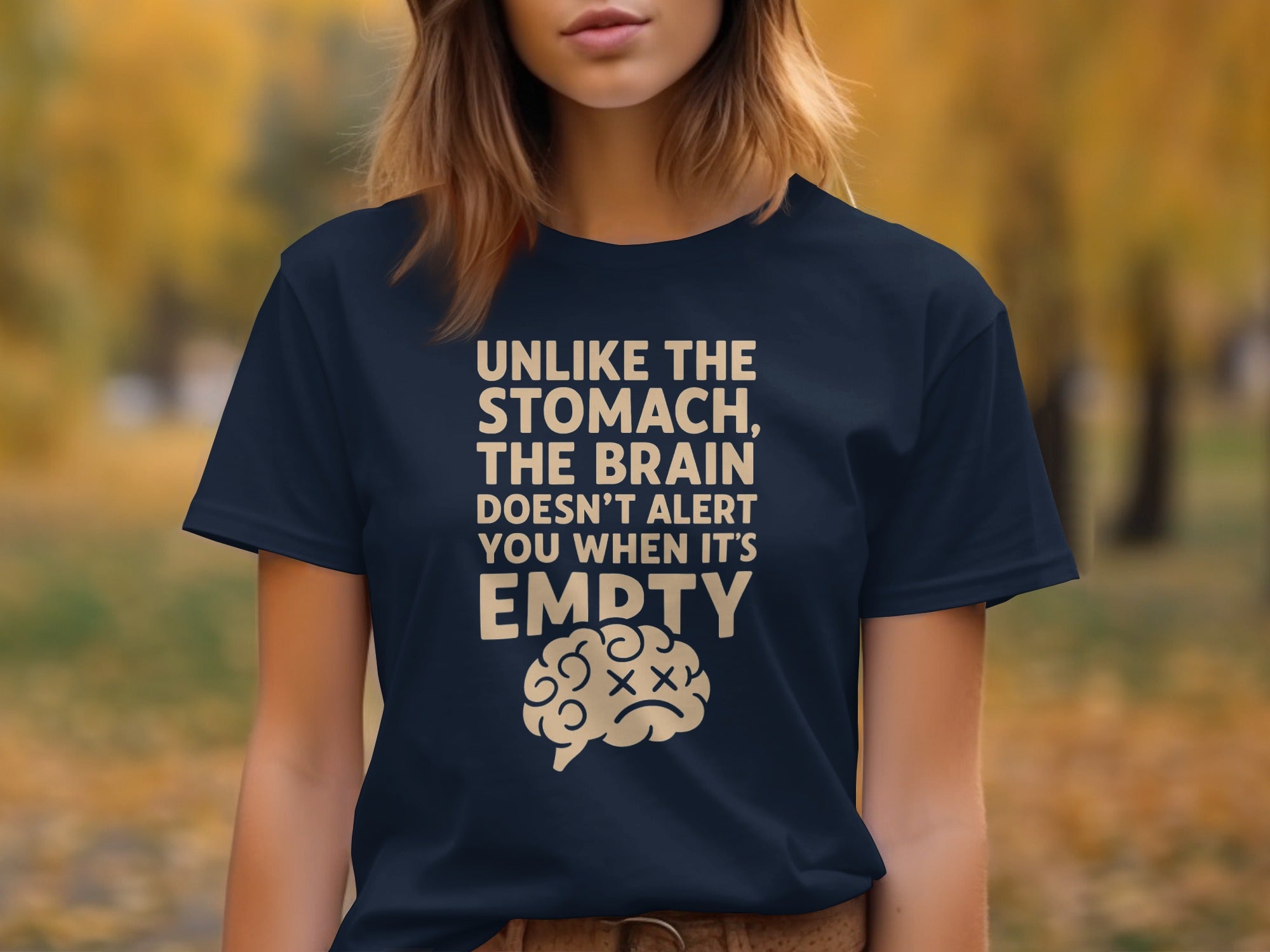 Person wearing a navy blue t-shirt with a humorous quote and brain graphic outdoors.