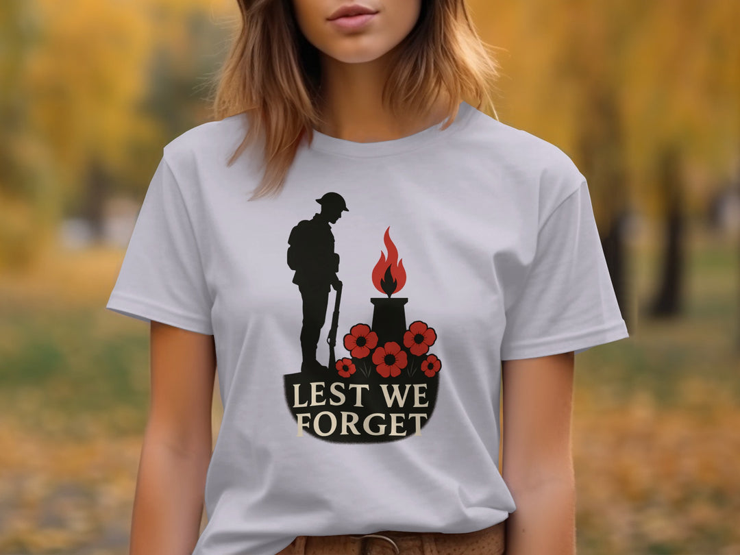 Person wearing a lavender t-shirt with a 'Lest We Forget' design outdoors.