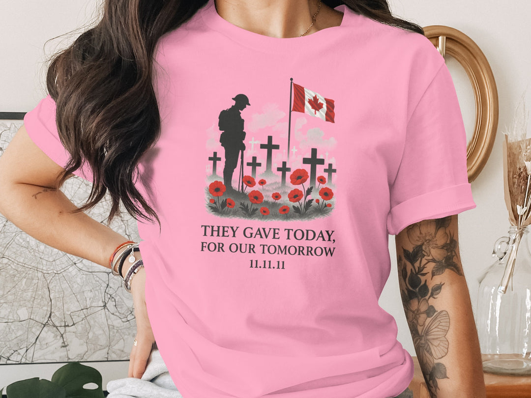 Person wearing a pink t-shirt with a graphic design and text, standing indoors.