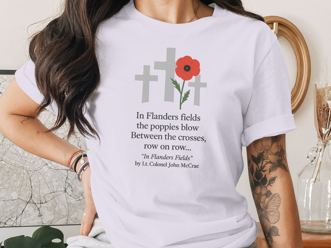 Person wearing a lavender t-shirt with a poppy and cross design and text.