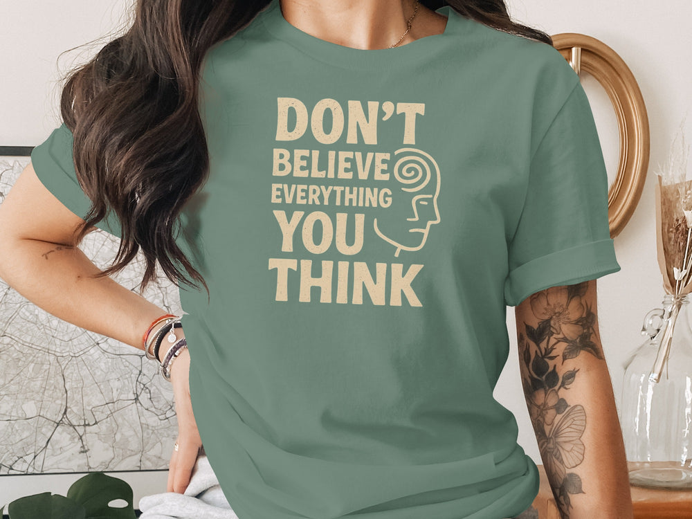 Person wearing a green t-shirt with a motivational quote indoors.