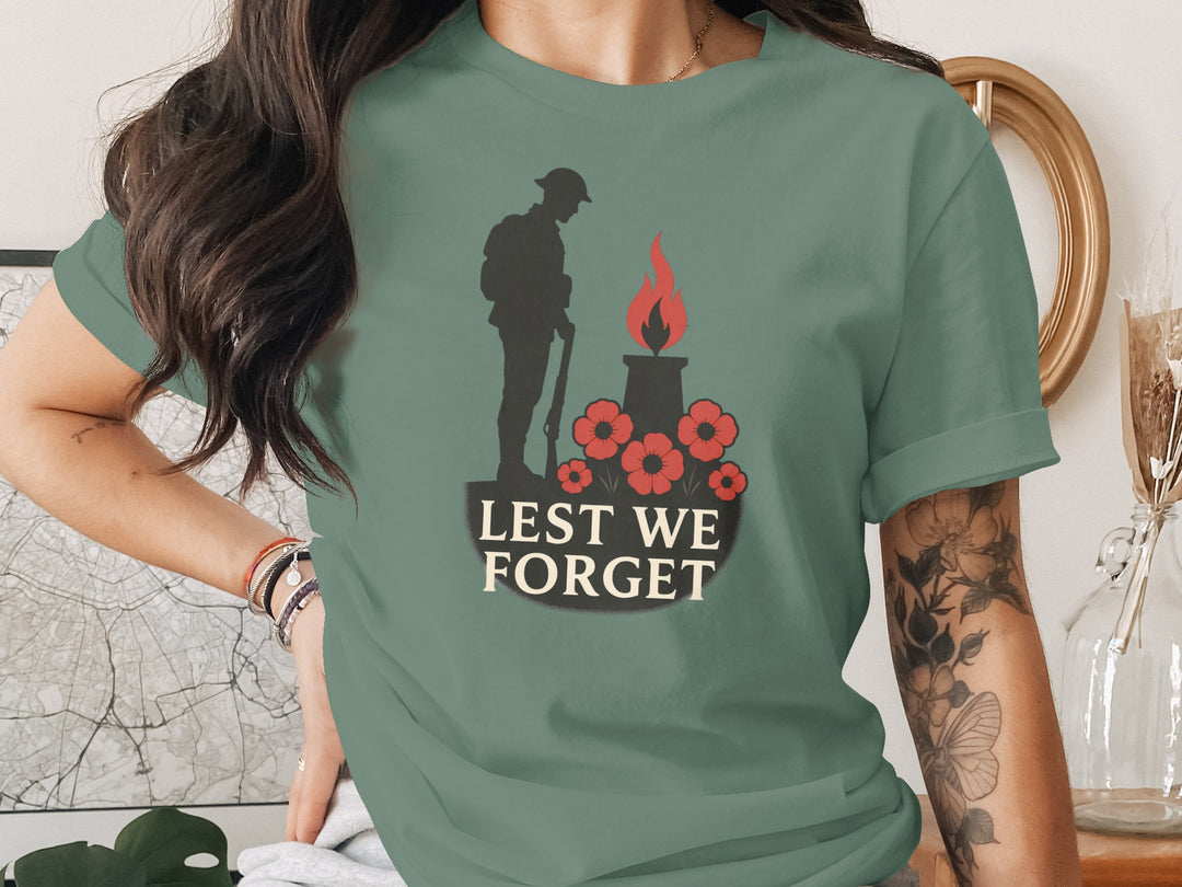 Person wearing a green t-shirt with a memorial design and 'Lest We Forget' text.