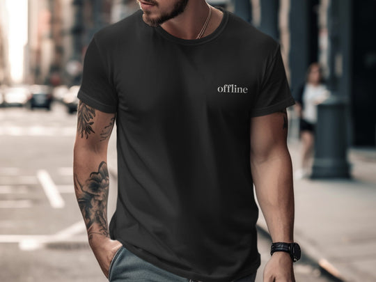 Man wearing a black t-shirt with 'offline' text on a city street.