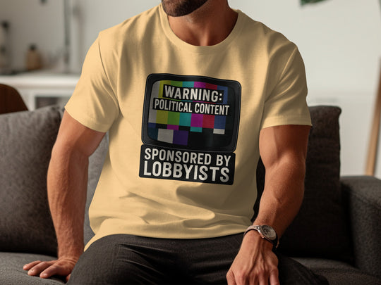 Person wearing a yellow t-shirt with a graphic and text, sitting on a couch.