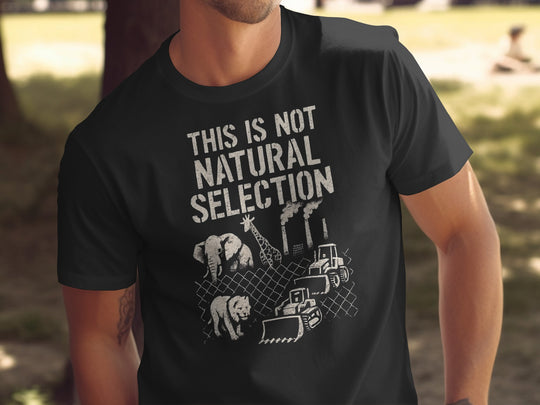 Person wearing a black t-shirt with a graphic and text 'THIS IS NOT NATURAL SELECTION' in an outdoor setting.
