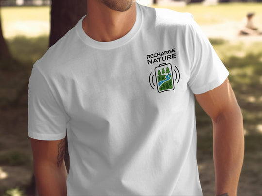 Person wearing a white t-shirt with 'Recharge Nature' graphic in a natural setting